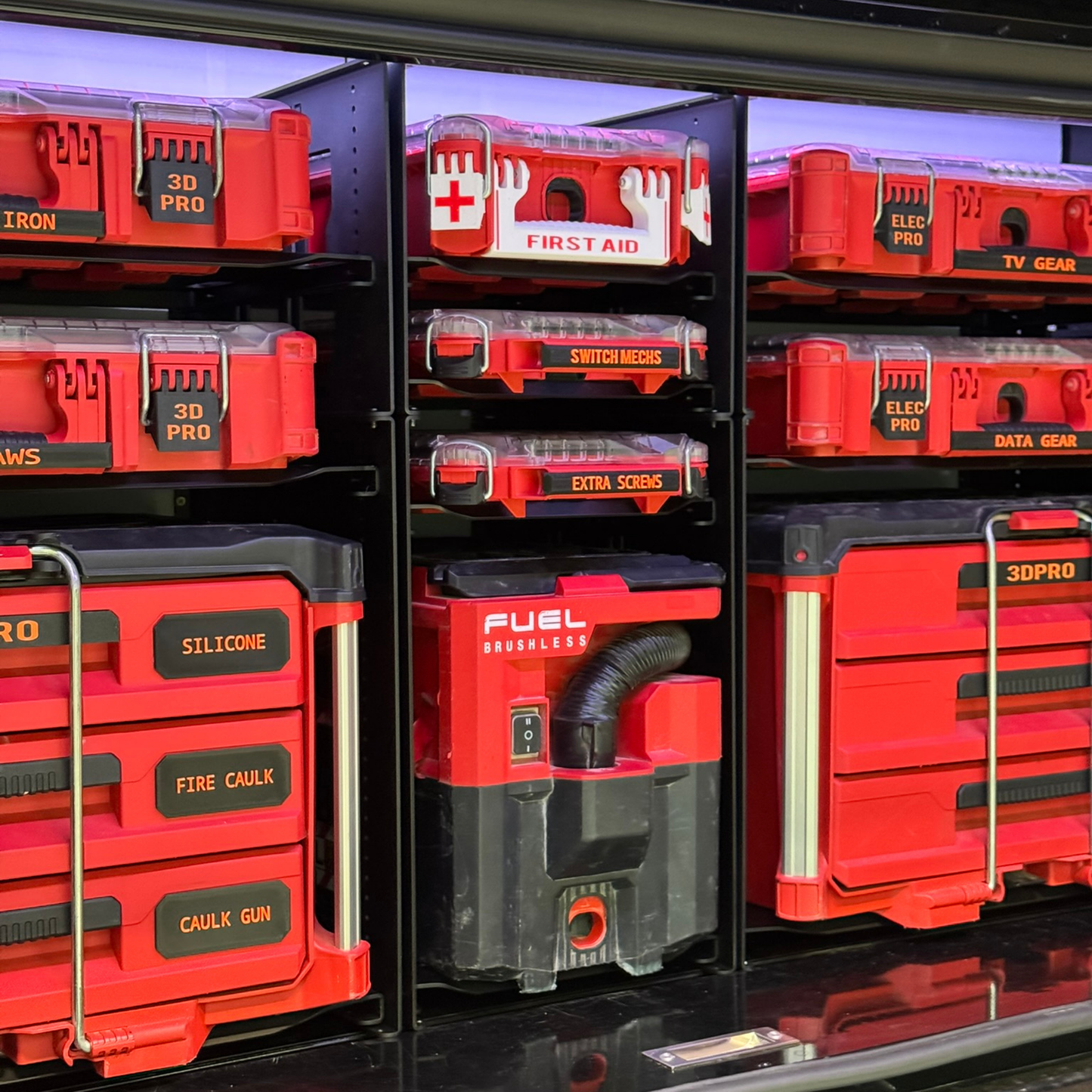 Storage drawers with various tool labels on a black background