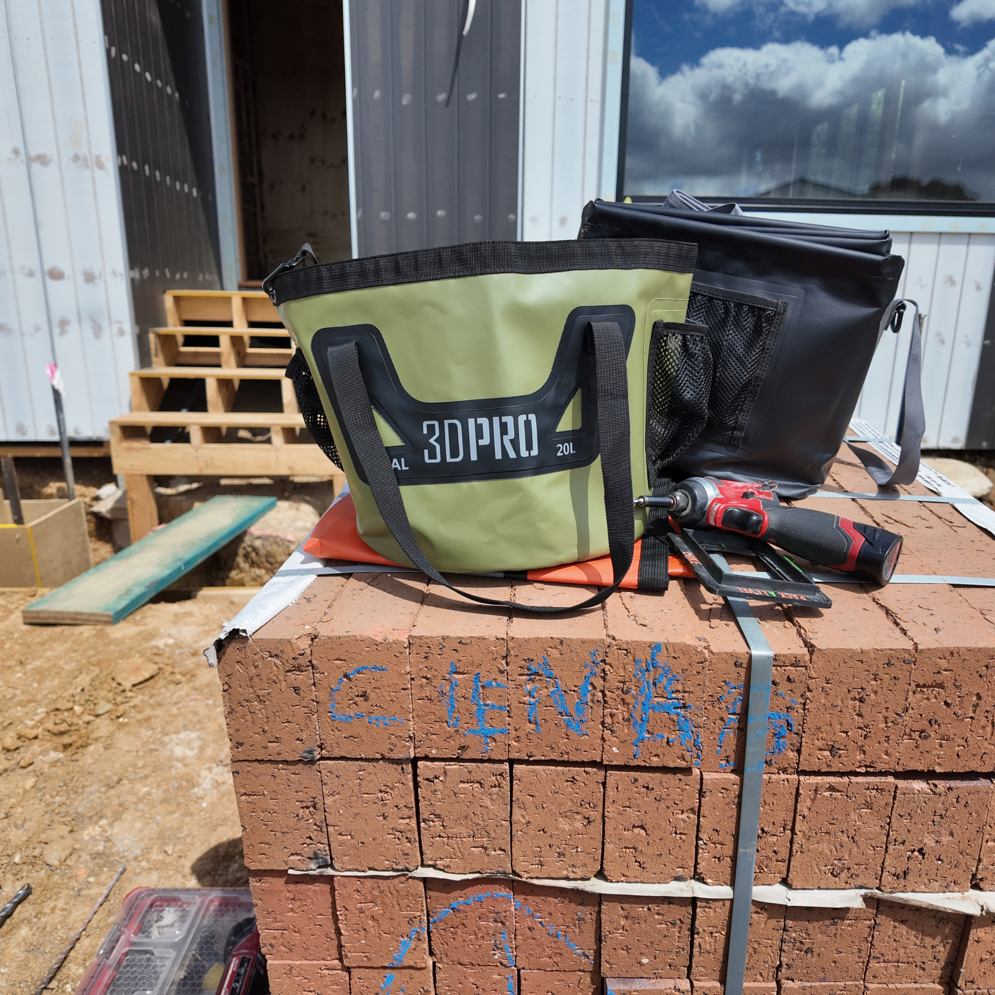 Green and black bag with '3DPRO' branding on a stack of bricks at a construction site.