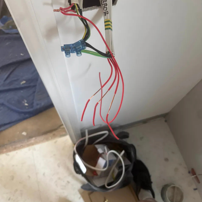 Electrical wiring with red and black wires on a white surface