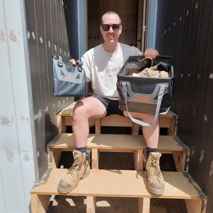 Luke sitting on wooden steps holding two 30L/8GAL Pro Square Folding Bucket