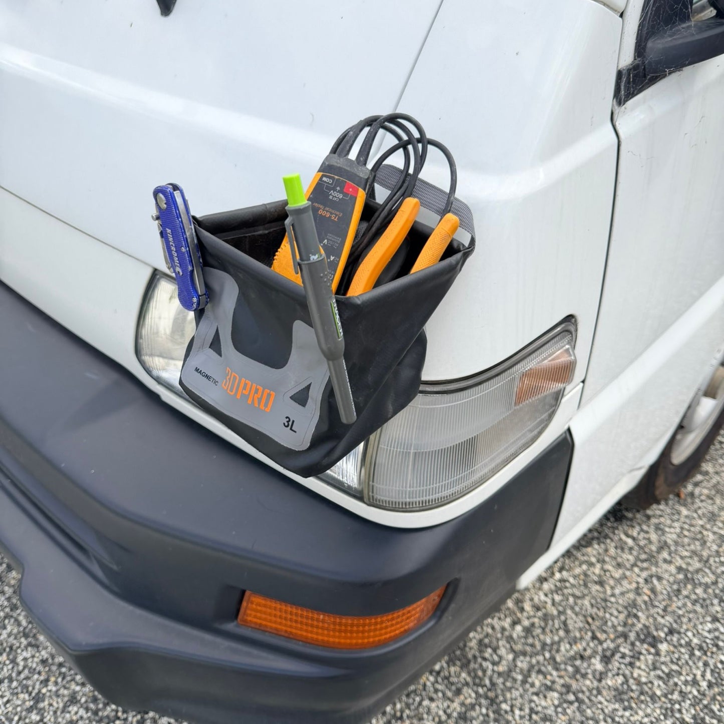 3L Pro Magnetic Folding Bucket with tools attached to a car's windshield