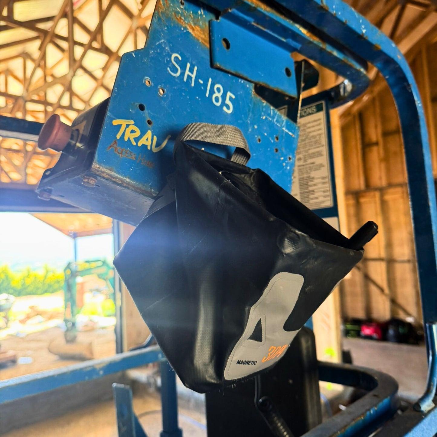 3L Pro Magnetic Folding Bucket On Site hanged on a Blue machine with a black bag labeled '4' in an industrial setting