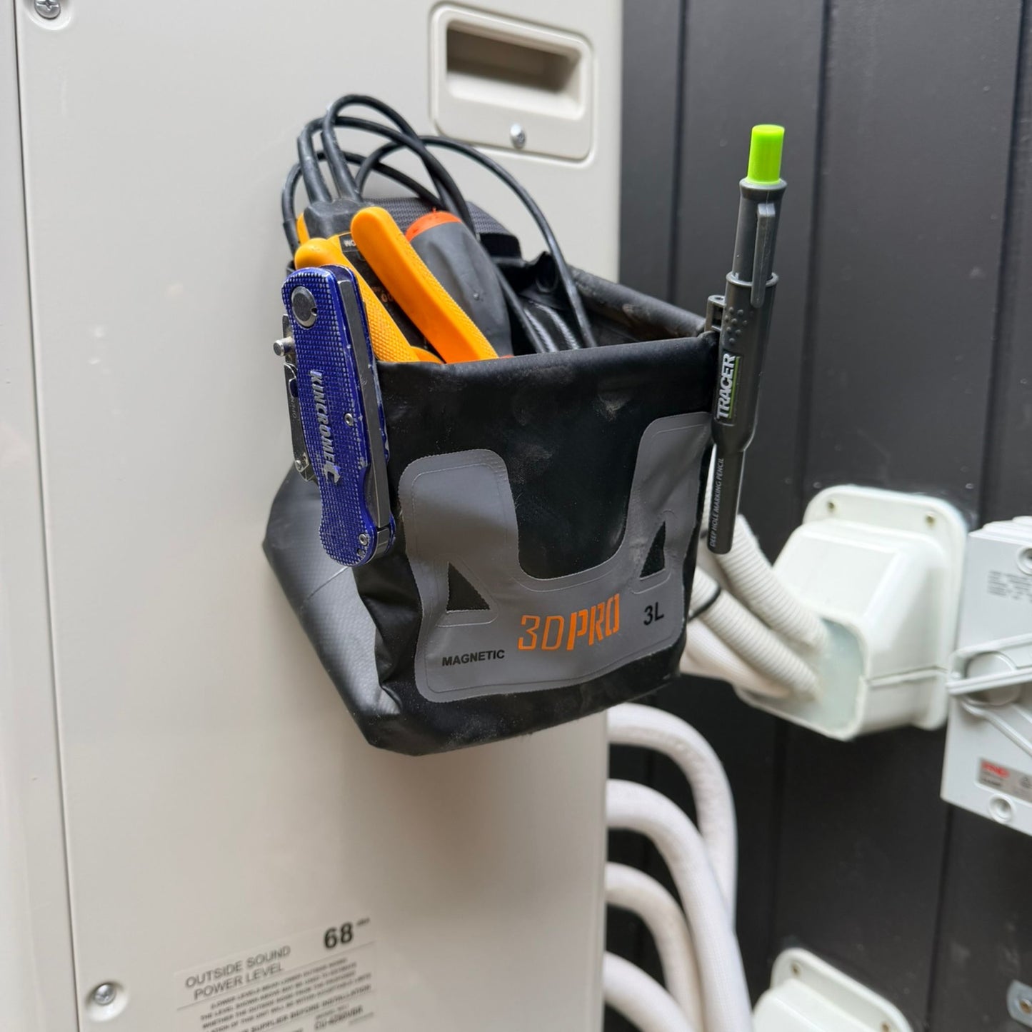 3L Pro Magnetic Folding Bucket On Site with tools attached to a wall-mounted device