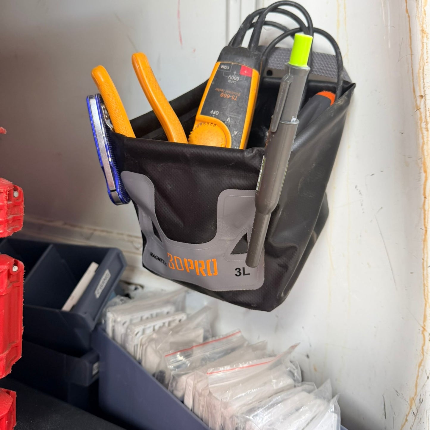 3L Pro Magnetic Folding Bucket On Site with tools inside, attached to a wall in a workshop setting.