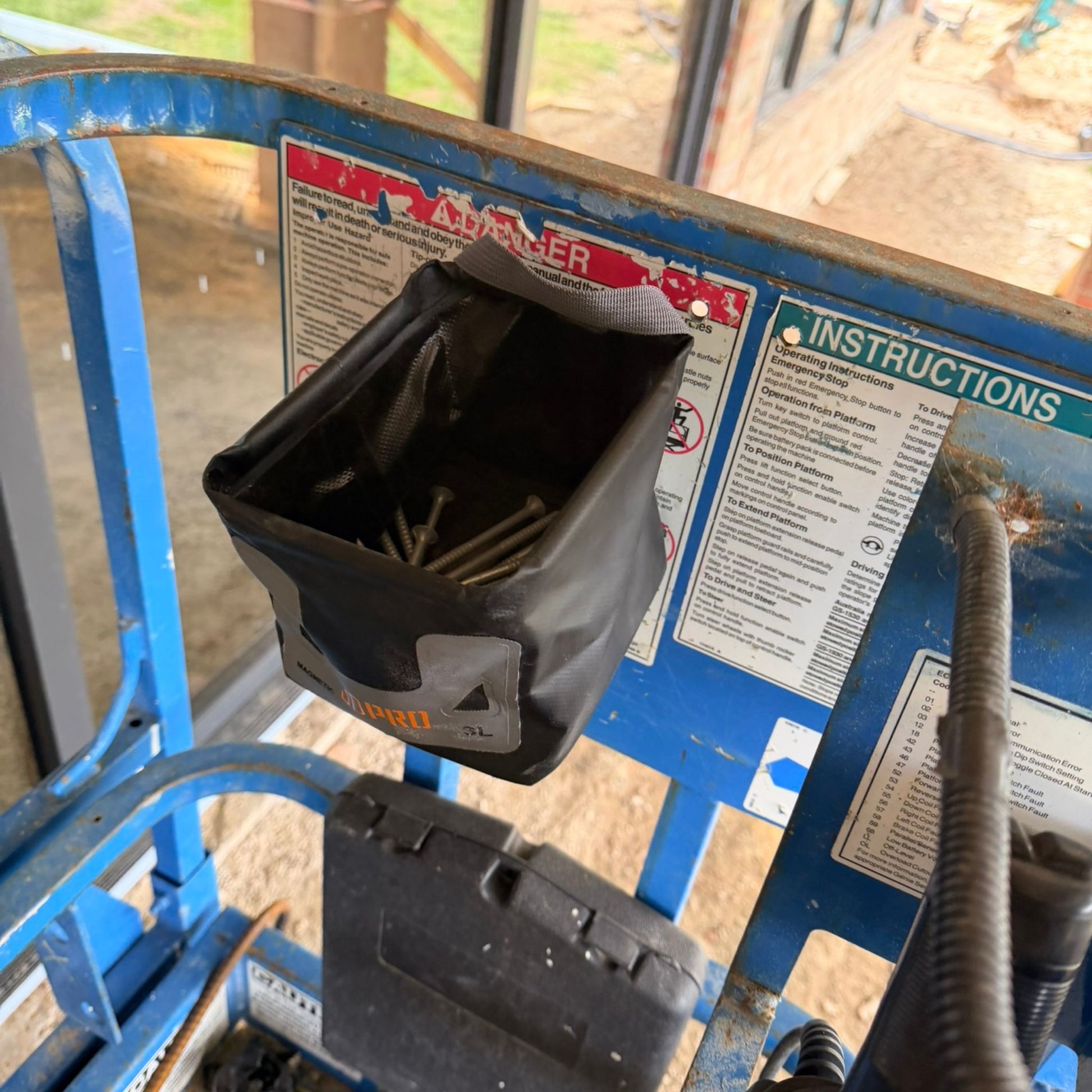 Black 3L Pro Magnetic Folding Bucket on a blue industrial platform with warning labels.