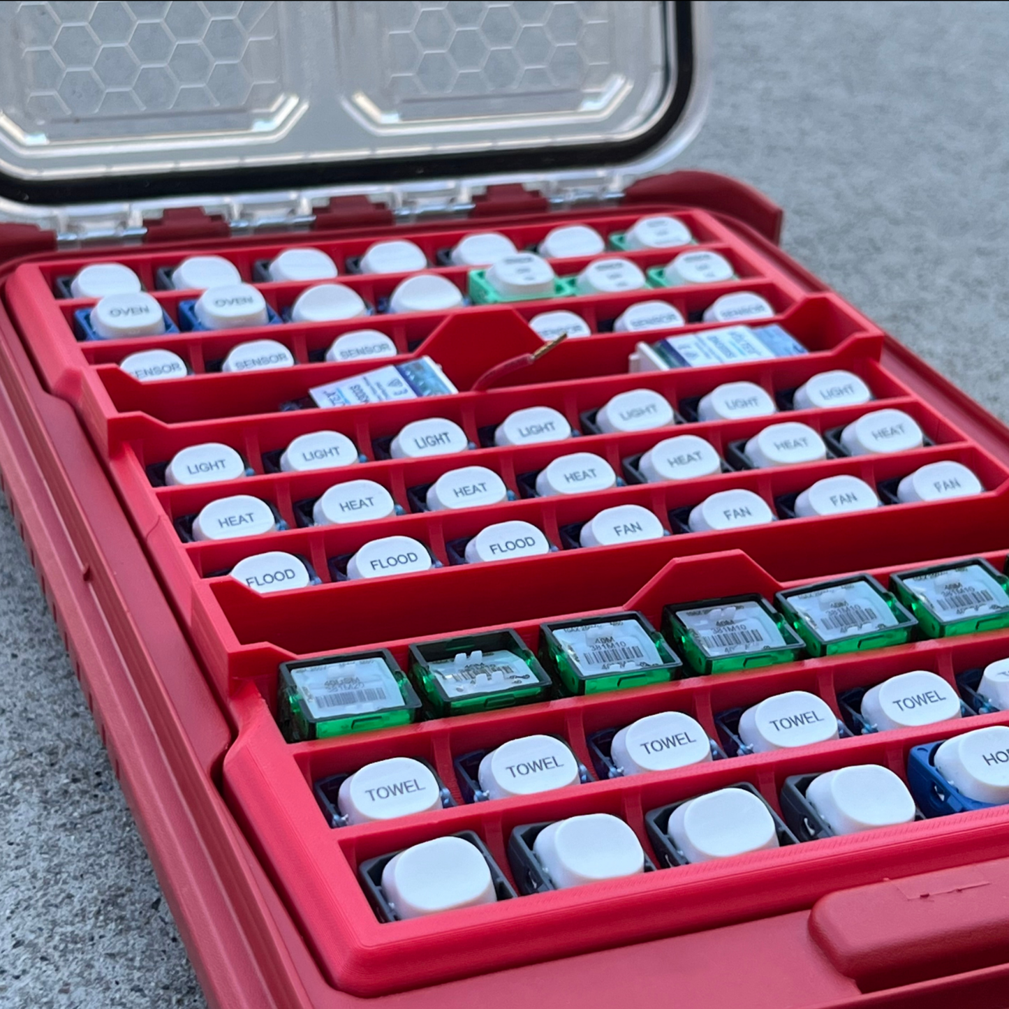 Milwaukee with 63x Switch Mech Insert Packout containing small electronic components on a concrete surface.