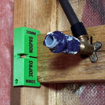 Pipe fitting with a green Nog Pro - Noggin SetBacks on a wooden surface