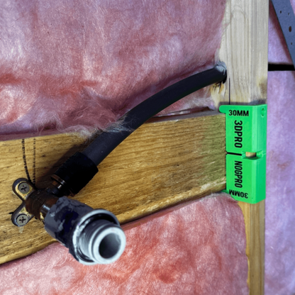Black hose connector on a wooden surface with green Nog Pro - Noggin SetBacks