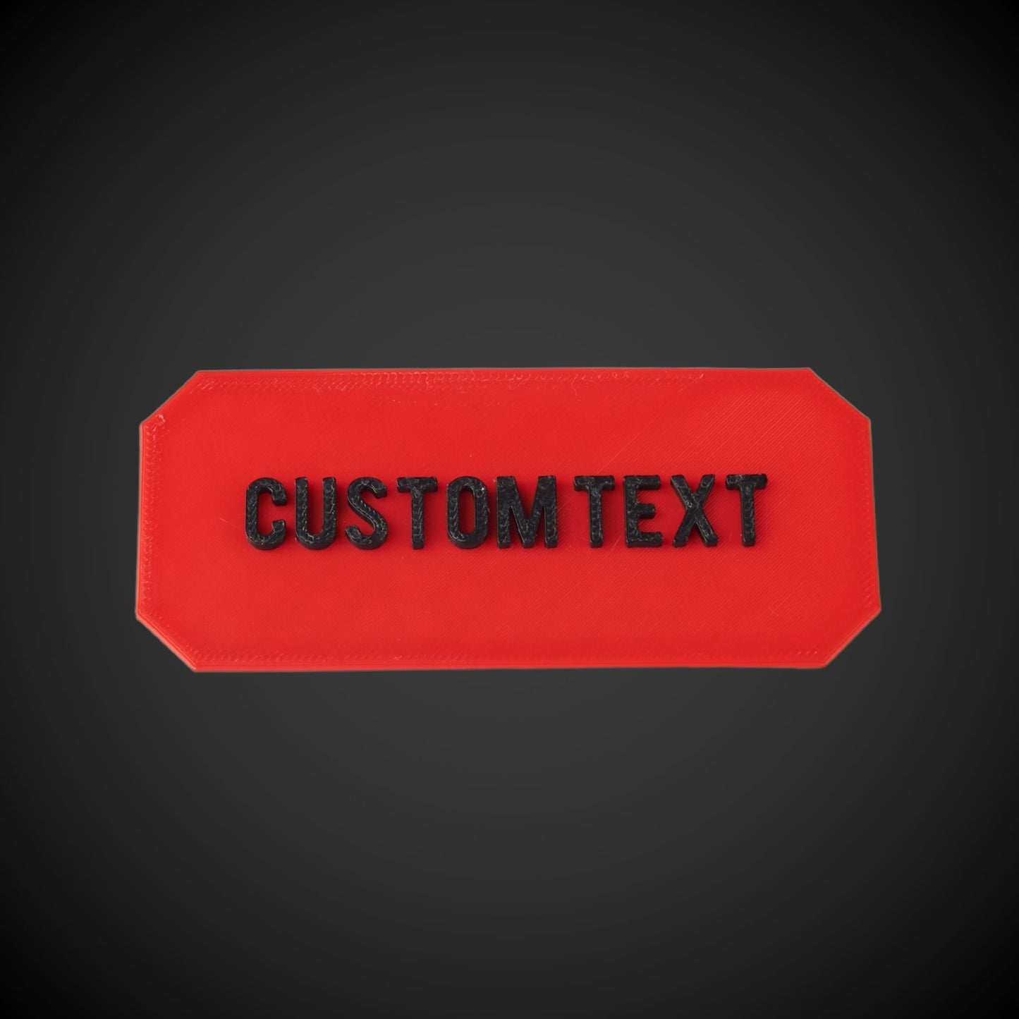 Red rectangular plate with 'CUSTOM TEXT' on a black background