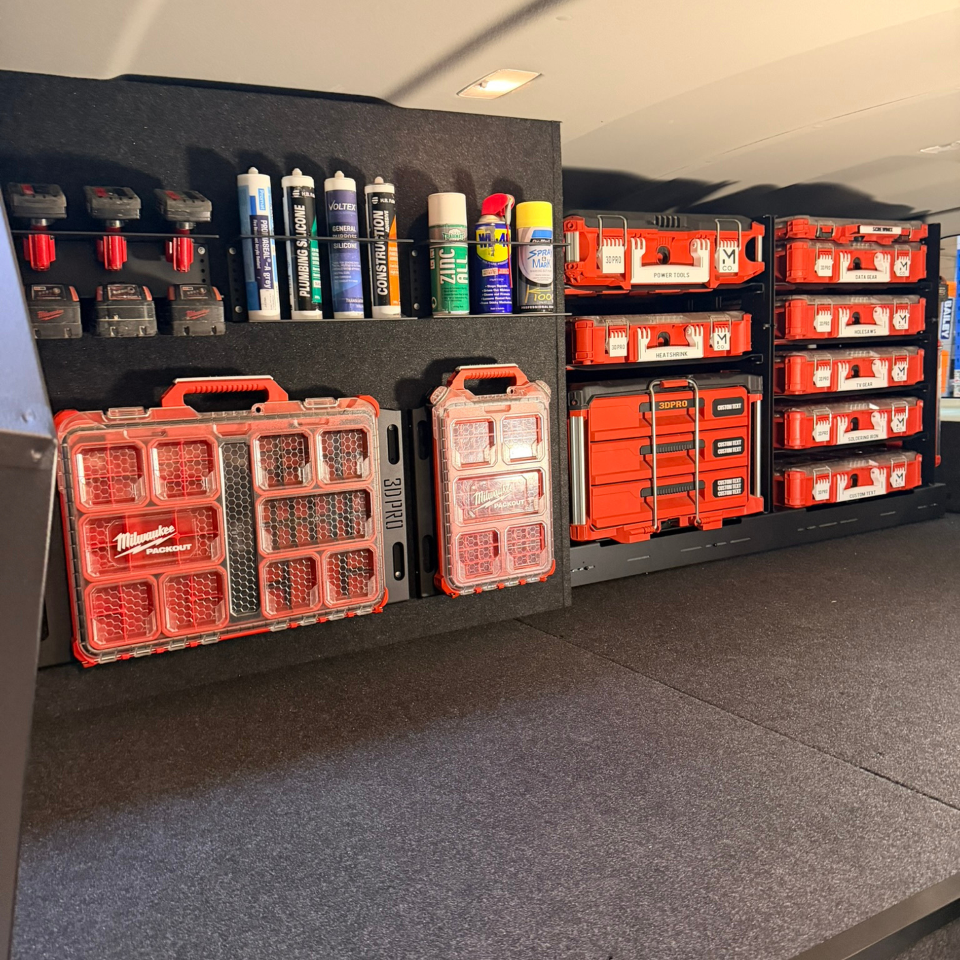 Storage area with red toolboxes and supplies on a gray floor.