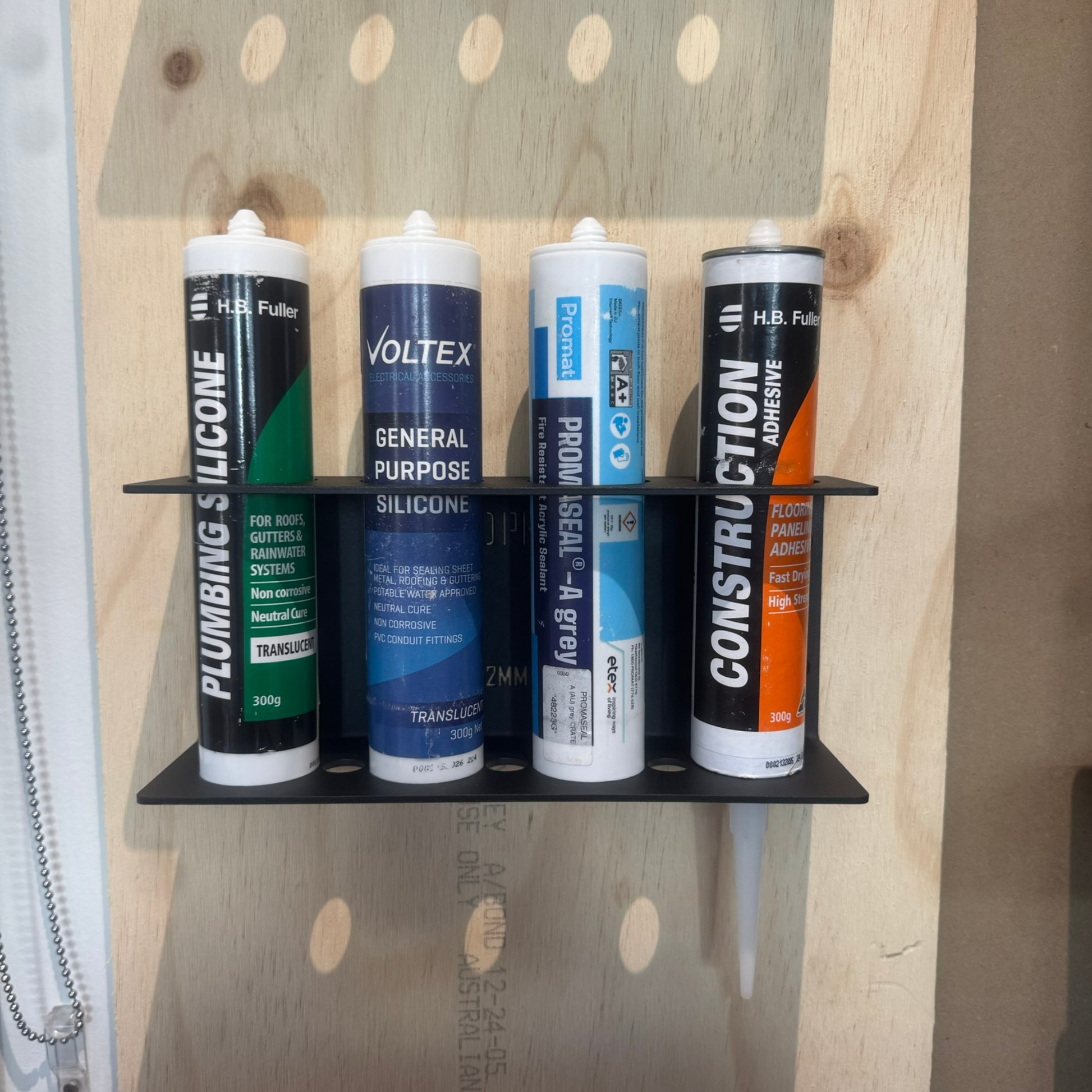 Four tubes of different types of sealant on a wooden surface