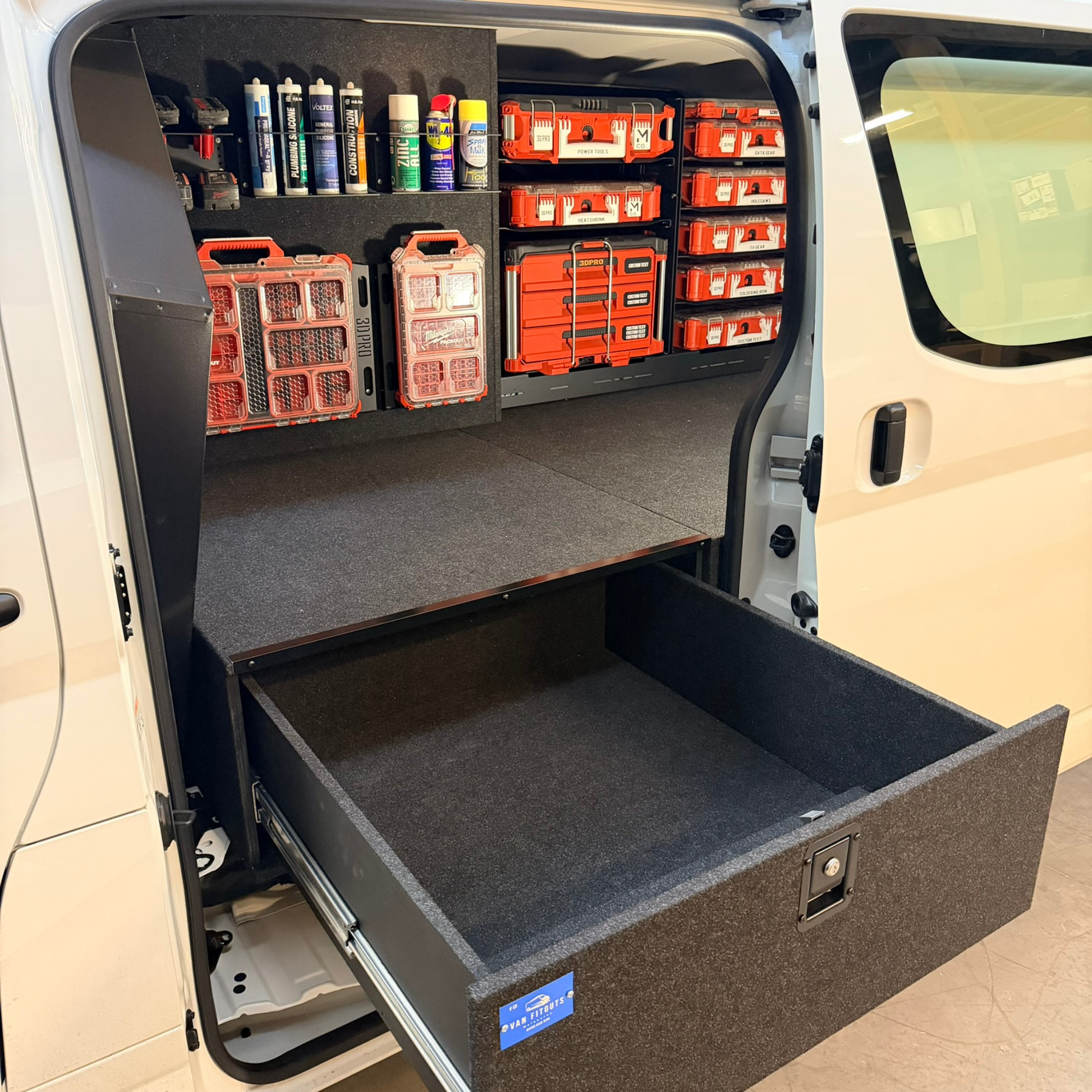 Van interior with storage compartments and tools organized neatly.